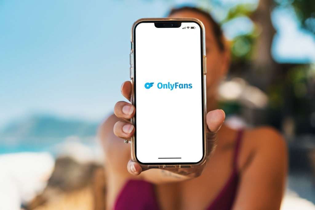 Woman working remotely on smartphone, representing the ease of OnlyFans income with VIP Escort’s full-service management
